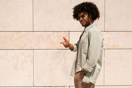 Outgoing Black man outdoor. African American man in casual clothes and sunglasses walking on sunny day. Portrait, city life conceptの写真素材