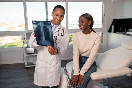 Tranquil African American woman at doctors appointment. Female patient sitting on sofa, doctor...