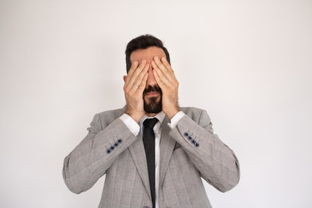 Irritated bearded man closing eyes with palms. Portrait of unhappy bearded man with closed eyes. Annoyance conceptの写真素材