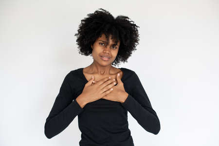Portrait of regretful African American woman looking at camera. Young female model wearing black...