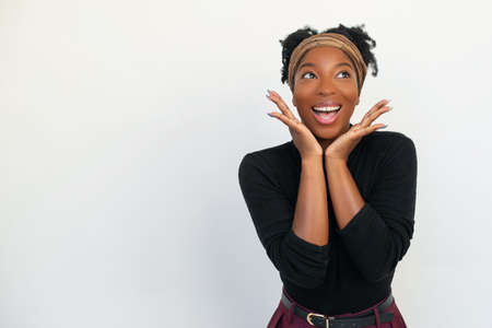 Portrait of delighted African American woman. Female model in black long sleeve shirt and trousers...