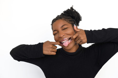 Comical African American woman making face. Female model with curly hair fooling around. Portrait, emotion conceptの写真素材