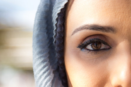 Close-up of Arabian woman brown eye with beautiful make up. Young woman in grey hijab looking straight. Beauty, cosmetics and make up conceptの写真素材