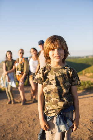 Portrait of happy little boy posing against family. Preteen child hiking with family in summer....