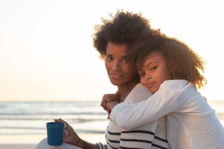 Portrait of content family at sunset. Mother and daughter smiling, hugging, looking at camera. Family, love, bonding conceptの写真素材
