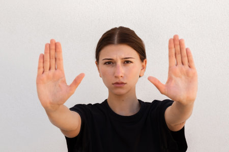 Portrait of serious young woman making refusal gesture over white background. Caucasian woman...