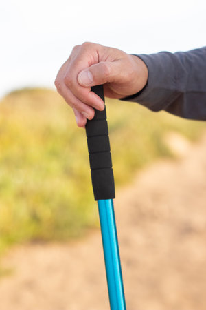 Close-up of male hand with walking pole. Man holding hiking equipment, hobby, leisure, activity conceptの写真素材