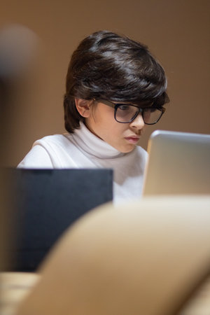 Serious boy in glasses programing using laptop. Schoolboy developing new application for school. Education, hobby conceptの写真素材