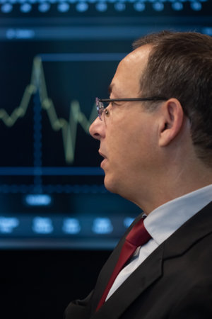 Close-up of financial analyst analyzing charts data. Serious man looking at big display, focused on...