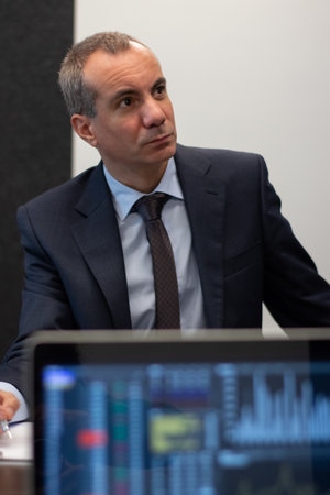 Portrait of businessman at his work place in office. Handsome man looking at digital screen with...