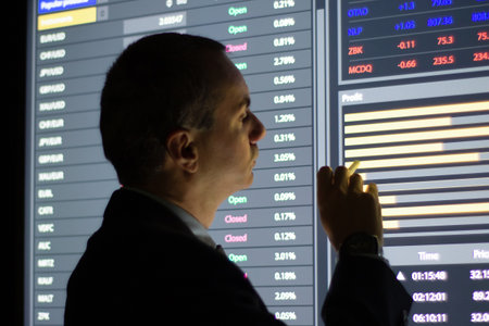 Close-up of financial analyst checking market data. Serious man looking at digital screen analyzing...