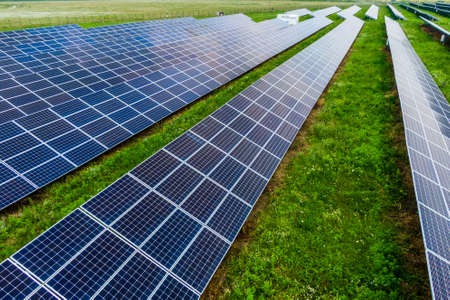 solar panes on green grass in a solar park used for clean energy production. aerial view. Drone photoの写真素材
