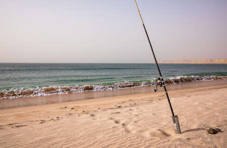 Fishing rod on a sand beach on a bright and sunny day, Atlantic ocean, Moroccoの写真素材