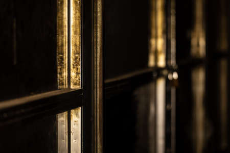 abstract background photo of golden window frame in a dark garage workshop at nightの写真素材