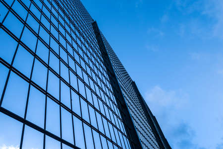 low angle view of a tall steel wire fence against blue skyの写真素材