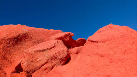 red painted rock formation against blue sky in the colored mountains of Morocco