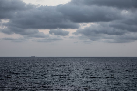 Vessel on the plain wide open ocean under an overcast skyの写真素材