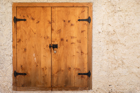 closed wooden window lids in stone wallの写真素材