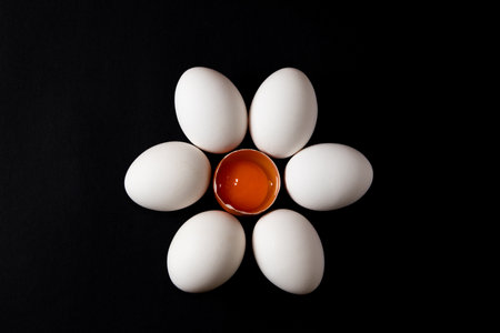 White eggs in a flower shape on black backgroundの写真素材