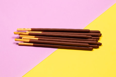 Chocolate-covered stick on purple and yellow background