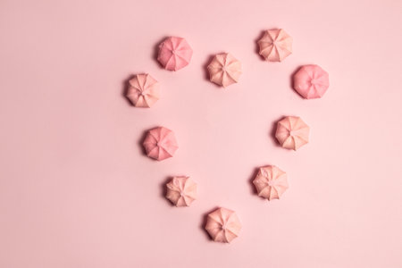 Heart shape of meringue cookies on pink backgroundの写真素材