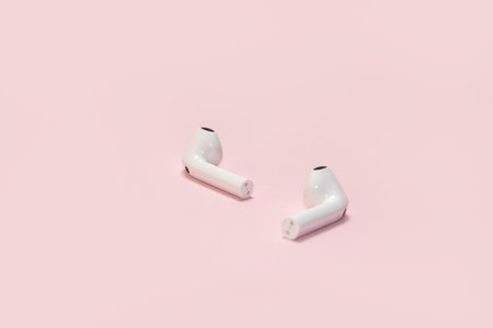 Wireless headphones on a pink background