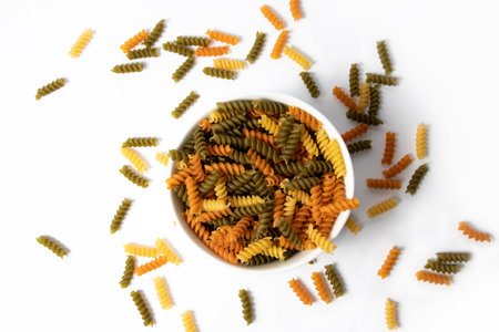 Tricolor pasta in a bowl on white backgroundの写真素材