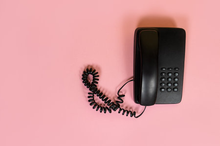 Top view of black telephone on pink backgroundの写真素材