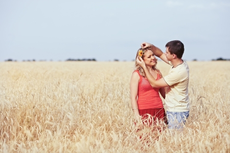 Guy catches a flower girl in a wheat fieldの写真素材