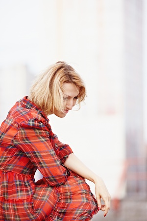 Beautiful girl in a red dress on the granite steps of theの写真素材
