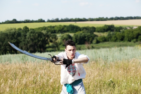 Slavic warrior in national dress with sword unsheathedの写真素材