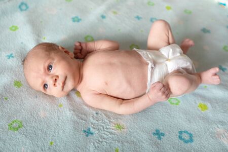Lying on the bed sheet baby at home