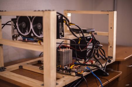 Video cards with on shelves connected to a farm for obtaining electronic money. Close-up. Out of...