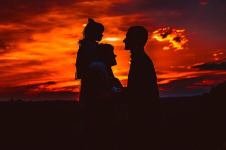 Happy family, father, mother, son and daughter in nature, sunsetの写真素材