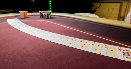 Dealer sitting in a casino at table while holding and distributing cardsの写真素材