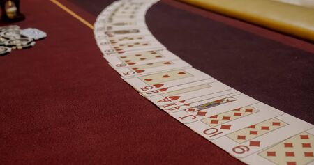 Dealer sitting in a casino at table while holding and distributing cards