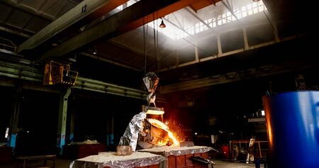 Smelting orange metal in a metallurgical plant. Liquid iron from the ladle