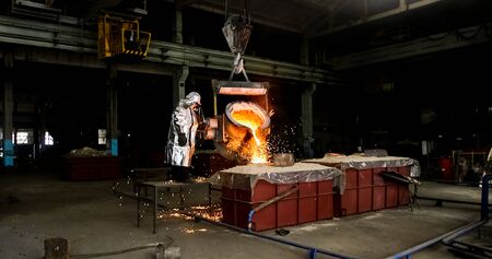 Smelting orange metal in a metallurgical plant. Liquid iron from the ladle