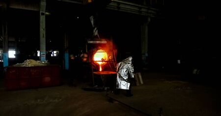 Smelting orange metal in a metallurgical plant. Liquid iron from the ladle