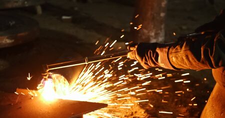 Stationary electric circular cutter instrument cuts metal blank.Professional welder workshop.Sparks...