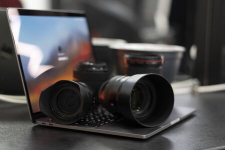 Digital camera, lens and laptop. concept of photographer work station. Working at home.