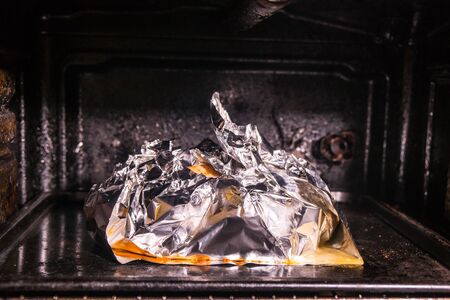 Cooking juicy golden chicken in oven and foil. Cooking yourself during the coronovirusの写真素材
