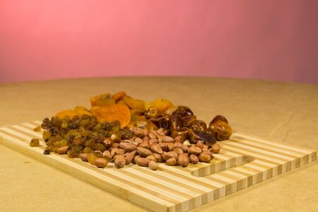 background of mixture of nuts and raisins, closeup. On a red background