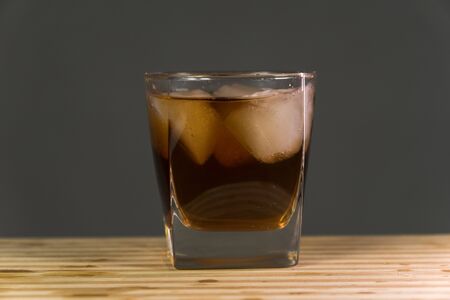 Glass of whiskey on wooden background close upの写真素材