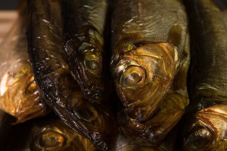 background of golden smoke-dried fish close up. On wooden backgroundの写真素材