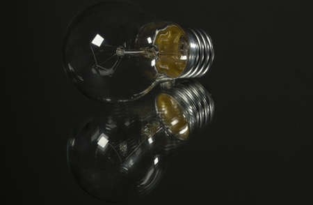 An old incandescent light bulb on black backgroundの写真素材