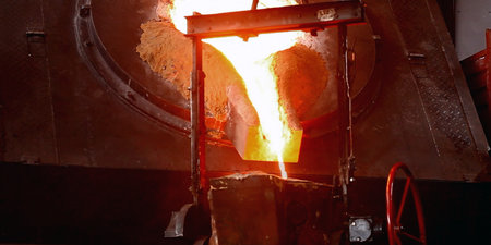 hot molten metal being poured into a mold in a metallurgical plant