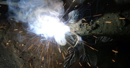 Welding of metal structures with sparks and smoke, industrial background