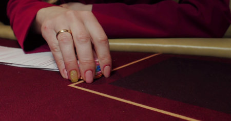 Closeup of a woman's hand holding a gold ring in her hand