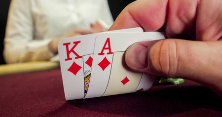 Playing cards in a casino with a man in the background, close-up